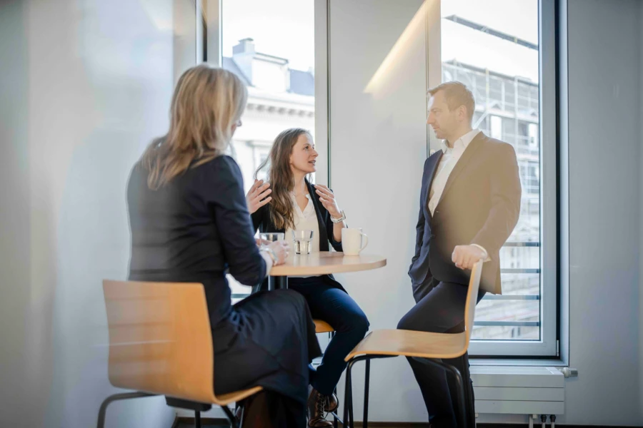 Drei Kolleg:innen unterhalten sich in der Teeküche